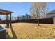 Large backyard features a fence, covered patio, and mature tree for outdoor enjoyment at 817 Nevis Way, Mcdonough, GA 30253