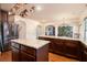 Open kitchen boasts dark wood cabinets, granite countertops, stainless steel appliances and stylish copper cookware accents at 817 Nevis Way, Mcdonough, GA 30253