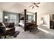 Comfortable main bedroom featuring four-poster bed, sitting area, and carpet at 817 Nevis Way, Mcdonough, GA 30253