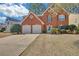Charming two-story red brick home with a two-car garage and well-maintained lawn and shrubbery at 2983 Bancroft Nw Gln, Kennesaw, GA 30144
