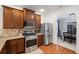 Well-lit kitchen features stainless steel appliances, granite countertops, and classic wood cabinetry at 313 Hidden Creek Lane, Canton, GA 30114