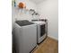 Functional laundry room features a washer, dryer, and storage shelving at 313 Hidden Creek Lane, Canton, GA 30114