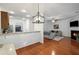 Open-concept view of the kitchen and living room featuring hardwood floors, fireplace, and breakfast bar at 313 Hidden Creek Lane, Canton, GA 30114