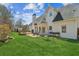 Green backyard featuring a deck, patio, play set, and mature trees at 5489 White Cedar Ter, Sugar Hill, GA 30518