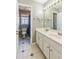 Well-lit bathroom with double vanity, a large mirror, and tile flooring at 5489 White Cedar Ter, Sugar Hill, GA 30518