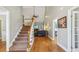 Spacious foyer featuring hardwood floors and staircase leading to an open-concept living space with modern finishes at 5489 White Cedar Ter, Sugar Hill, GA 30518
