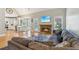 Open-concept living room with fireplace, TV and a view into the home's bright kitchen at 5489 White Cedar Ter, Sugar Hill, GA 30518