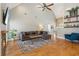Cozy living room with high ceilings, a stone fireplace, hardwood floors and a stylish sectional sofa at 5489 White Cedar Ter, Sugar Hill, GA 30518