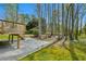 A wooden deck with steps leads into a backyard surrounded by towering trees and lush nature at 6317 Southland Forest Dr, Stone Mountain, GA 30087