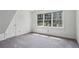 Bedroom featuring a large window providing natural light with an adjacent door and neutral carpet at 6317 Southland Forest Dr, Stone Mountain, GA 30087