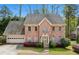 Elegant two-story brick home featuring a two-car garage, lush landscaping, and a classic architectural design at 6317 Southland Forest Dr, Stone Mountain, GA 30087