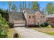 Two-story brick home with an attached two-car garage, driveway, and landscaped front yard with mature trees at 6317 Southland Forest Dr, Stone Mountain, GA 30087
