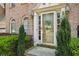 Charming brick home entrance with decorative glass door, sidelights, arched windows, and manicured landscaping at 6317 Southland Forest Dr, Stone Mountain, GA 30087