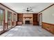 Bright living room with brick fireplace, built-in shelving, and large windows offering scenic views at 6317 Southland Forest Dr, Stone Mountain, GA 30087