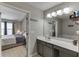 Bright bathroom with gray cabinets, white counters, and a connecting bedroom at 3826 Dandridge Way, Duluth, GA 30096