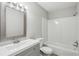 Bathroom features a modern gray vanity, framed mirror, and bathtub with shower at 4322 Idlewood Ln, Tucker, GA 30084