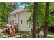 A back exterior shot displays a beautiful home with a large deck and natural surroundings at 100 Oakwind Pkwy, Canton, GA 30114