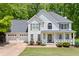 Charming two-story home with a three-car garage, landscaped front yard, and welcoming front porch at 100 Oakwind Pkwy, Canton, GA 30114