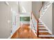 Bright foyer with hardwood floors, a staircase, and views into the formal dining room at 100 Oakwind Pkwy, Canton, GA 30114