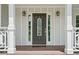 A close-up of the front door with decorative glass, sidelights, and classic lantern-style sconces at 100 Oakwind Pkwy, Canton, GA 30114