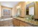 Main bathroom featuring dual vessel sinks, granite countertops, and a soaking tub at 100 Oakwind Pkwy, Canton, GA 30114