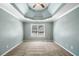 Spacious main bedroom featuring tray ceiling, carpet, and a large window at 100 Oakwind Pkwy, Canton, GA 30114