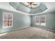 Large main bedroom with tray ceiling, neutral carpet, and abundant natural light at 100 Oakwind Pkwy, Canton, GA 30114