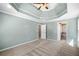 Large main bedroom with tray ceiling, neutral carpet, and ensuite bathroom access at 100 Oakwind Pkwy, Canton, GA 30114