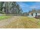 Lush backyard featuring sodded grass, a wood fence, and a charming deck area at 5155 Rosestone Nw Dr, Lilburn, GA 30047