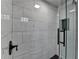 Shower featuring white marble tiles, black fixtures, and glass door at 5155 Rosestone Nw Dr, Lilburn, GA 30047