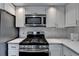 Modern kitchen features stainless steel appliances, white cabinets, subway tile backsplash, and white quartz countertops at 5155 Rosestone Nw Dr, Lilburn, GA 30047