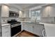 Bright kitchen features stainless steel appliances, white cabinets, and lots of natural light at 5155 Rosestone Nw Dr, Lilburn, GA 30047