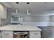 Open concept kitchen with quartz countertops overlooks the living room featuring modern pendant lighting and dark wood floors at 5155 Rosestone Nw Dr, Lilburn, GA 30047