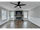 Cozy living room with stone fireplace, ceiling fan, and hardwood floors at 5155 Rosestone Nw Dr, Lilburn, GA 30047