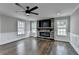 Cozy living room with stone fireplace, ceiling fan, and hardwood floors at 5155 Rosestone Nw Dr, Lilburn, GA 30047