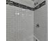 Tile shower with white subway tile and a black and white accent stripe at 5155 Rosestone Nw Dr, Lilburn, GA 30047