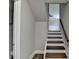 Stairway with gray walls and wood stairs leads to the upper level at 5155 Rosestone Nw Dr, Lilburn, GA 30047