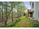 A spacious backyard with a lush lawn, mature trees, beautiful garden bed, and an elevated deck at 819 Holly Rdg, Canton, GA 30115