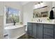 Bathroom featuring a freestanding tub, vanity with drawers, and a large mirror at 819 Holly Rdg, Canton, GA 30115