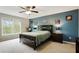 Comfortable bedroom with a ceiling fan, a large window, and a blue accent wall at 819 Holly Rdg, Canton, GA 30115