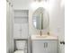 Small bathroom with large round mirror, modern vanity and ample lighting at 4460 Dalston Ne Dr, Atlanta, GA 30342