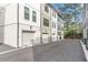 Street view of row of townhome garages with white doors and paved driveway at 4460 Dalston Ne Dr, Atlanta, GA 30342