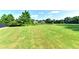 A serene backyard view of lush green lawn and a pond in the distance at 5190 Deerlake Dr, Alpharetta, GA 30005