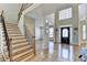 Inviting foyer with staircase, detailed front door, large window, and hardwood floors at 5190 Deerlake Dr, Alpharetta, GA 30005