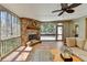 Relaxing screened porch with stone fireplace, ceiling fan, tiled flooring, and access to the backyard at 5190 Deerlake Dr, Alpharetta, GA 30005