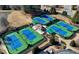 Aerial view of a vibrant tennis center with multiple courts, lush landscaping, and a charming clubhouse at 5190 Deerlake Dr, Alpharetta, GA 30005