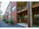 Exterior view of brick townhome featuring fenced patio and upper wood balcony at 1096 Holly Ave, Atlanta, GA 30338
