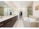 Luxurious bathroom featuring dual sinks, a soaking tub, and a separate glass-enclosed shower at 1096 Holly Ave, Atlanta, GA 30338