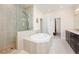 Elegant bathroom showcases soaking tub with shower head and dual sink vanity with cabinetry at 1096 Holly Ave, Atlanta, GA 30338