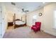 Spacious bedroom with a four poster bed, ceiling fan, and a cozy red accent chair at 1096 Holly Ave, Atlanta, GA 30338